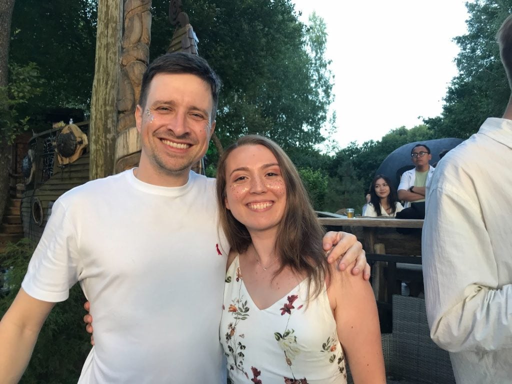 Dois funcionários da Hostinger sorridentes, abraçados e posando para a foto